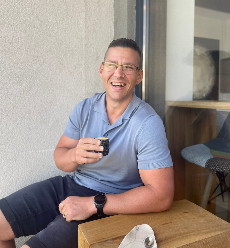 Ricky smiling with an espresso cup