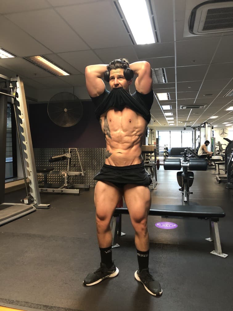 Ricky tensing his abs in the gym
